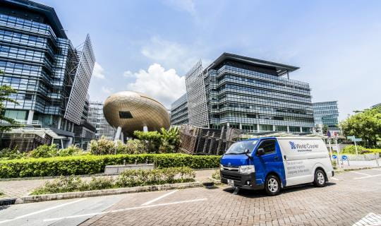 A World Courier van is parked in front of a city skyline