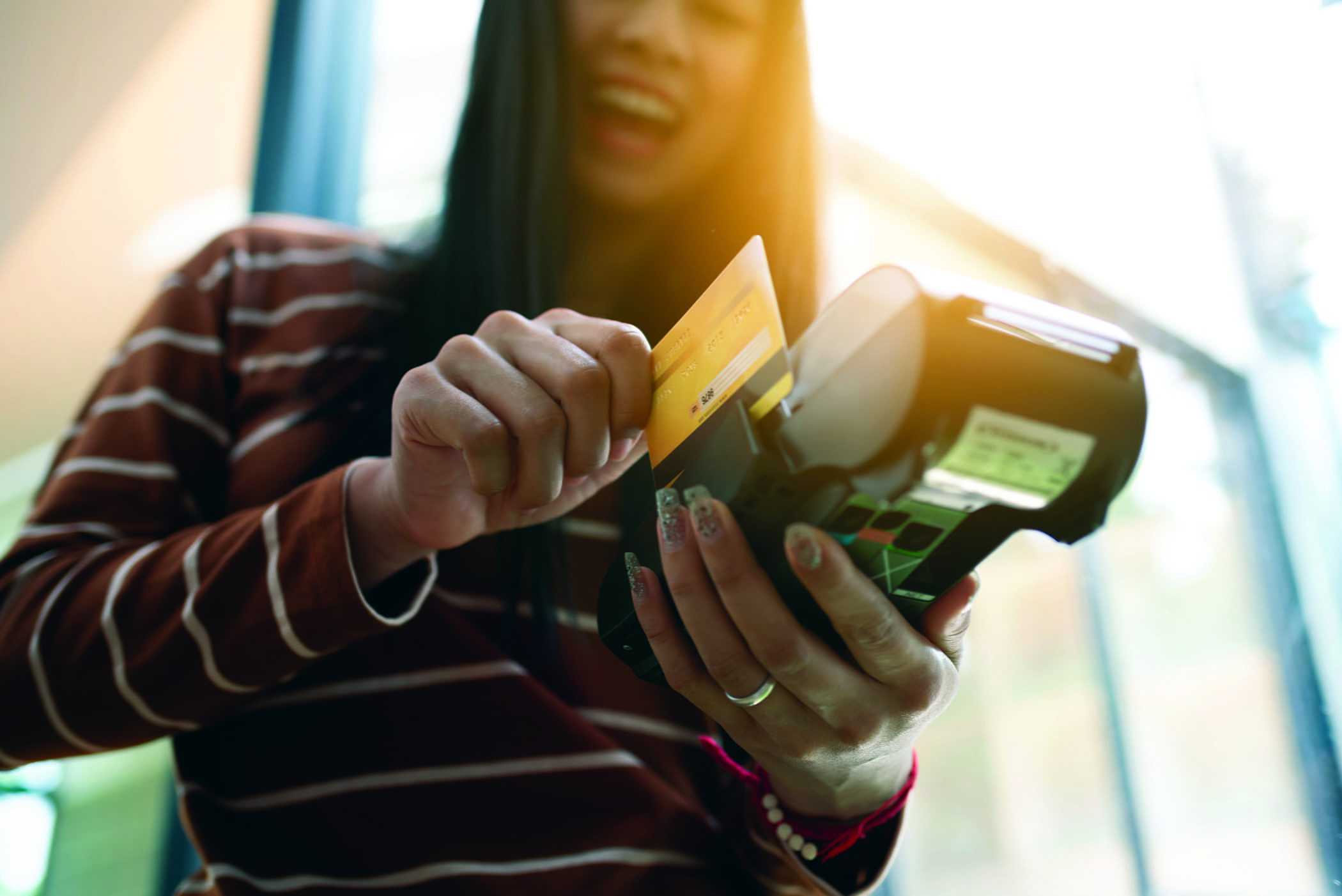 Millennial swiping her debit card to make a purchase